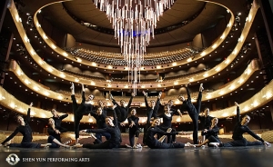 Участники труппы Shen Yun World Company позируют в Winspear Opera House в Далласе штата Техас. Он был спроектирован как ультрасовременная версия традиционного оперного театра. Сзади видна огромная опускающаяся люстра.