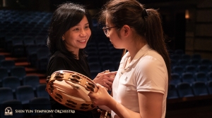 Concertmaster Chia-Chi Lin sharing a tip with percussionist Jazmine Jia.
